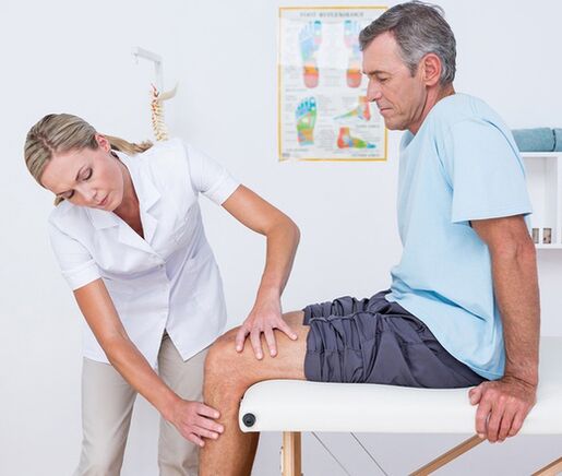 Liječnik provodi vizualni pregled i palpaciju pacijenta s bolovima u koljenu